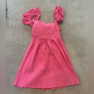 Hot pink mini dress with ruffles on the sleeve and an open back with a tie